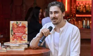 Matteo Brunetti z mikrofonem obok swojej książki "Włoska uczta". Czy popularny kucharz naprawdę uczył się gotować w zagranicznej rodzinie?