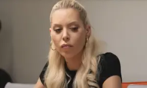 Julia von Stein z blond włosami i kolczykami w kształcie kółek, zamyślona.