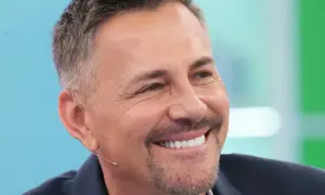 Uśmiechnięty Krzysztof Ibisz, którego wiek jest często przedmiotem dyskusji, w garniturze.