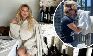 Eva Halina Rich w swetrze siedzi przy stole, a obok niej wesoło przytula białego zwierzaka.