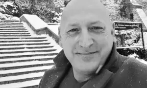 Jacek Wójcik, w zimowej scenerii, na tle zaśnieżonych schodów. Wiek nie jest widoczny, ale uśmiech sugeruje radość.