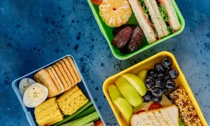 Czy warto kupić catering dietetyczny od najpopularniejszej trenerki fitness? Trzy pudełka pełne zdrowych przekąsek: kanapki, owoce, warzywa, jajka, krakersy.