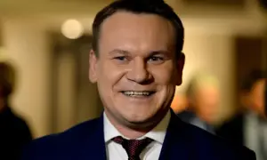 Uśmiechnięty mężczyzna w garniturze, z krawatem. Czy Tarczyński jest żonaty? To pytanie, na które odpowiedź może być ukryta w jego spojrzeniu.