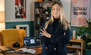 Kobieta w marynarce zastanawia się, czy kurs online o pewności siebie od influencerki jest wart swojej ceny.