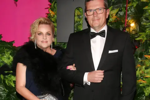 Marcin Bosacki z nową partnerką na ściance. Elegancka para pozuje na tle zieleni i różu.