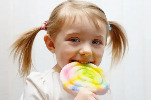 Czy dzieci celebrytów jedzą cukier i fast foody? Ta dziewczynka z pewnością cieszy się kolorowym lizakiem.