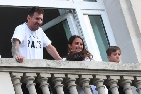 Lionel Messi z rodziną na balkonie, uśmiechnięci.