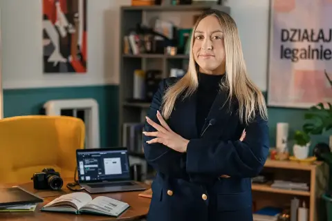 Kobieta w marynarce zastanawia się, czy kurs online o pewności siebie od influencerki jest wart swojej ceny.