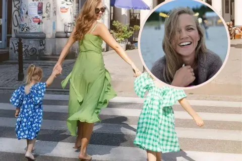 Agnieszka Kaczorowska z dziećmi przechodzi przez pasy. Uśmiechnięta mama prowadzi córeczki.