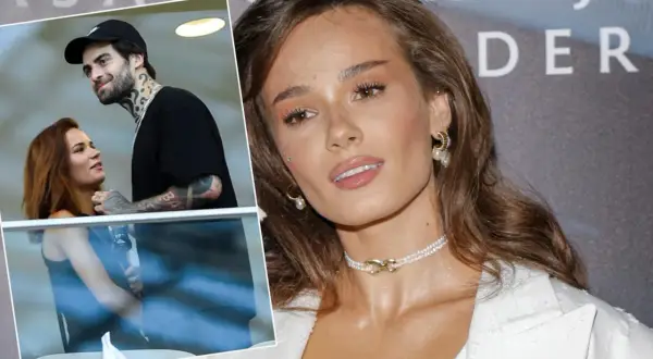 Natalia Szroeder z partnerem, uśmiechnięci i blisko siebie. W tle widać fragmenty napisu.