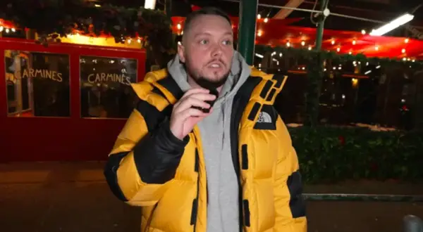 Książulo w żółtej kurtce przed restauracją Carmines, gdzie jego recenzja obiadu była negatywna.