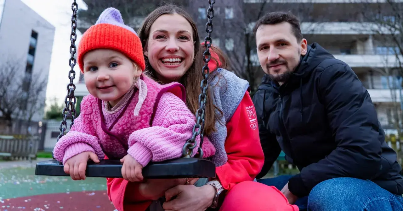 Rodzina na placu zabaw. Dziecko w różowym sweterku i czapce, obok uśmiechnięta mama i tata. To przykład listy dzieci gwiazd, które pracują w zwykłych zawodach poza branżą.