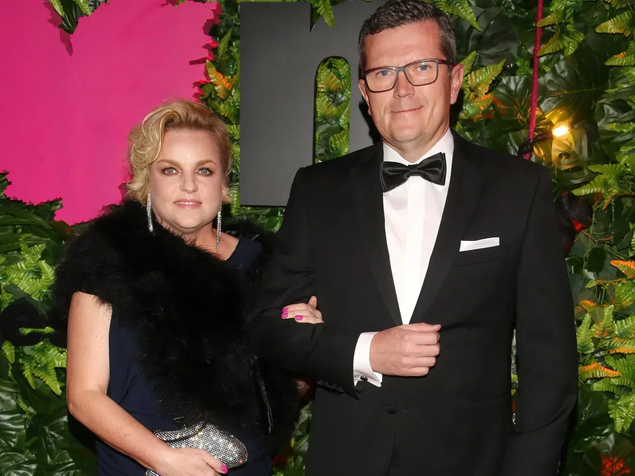 Marcin Bosacki z nową partnerką na ściance. Elegancka para pozuje na tle zieleni i różu.