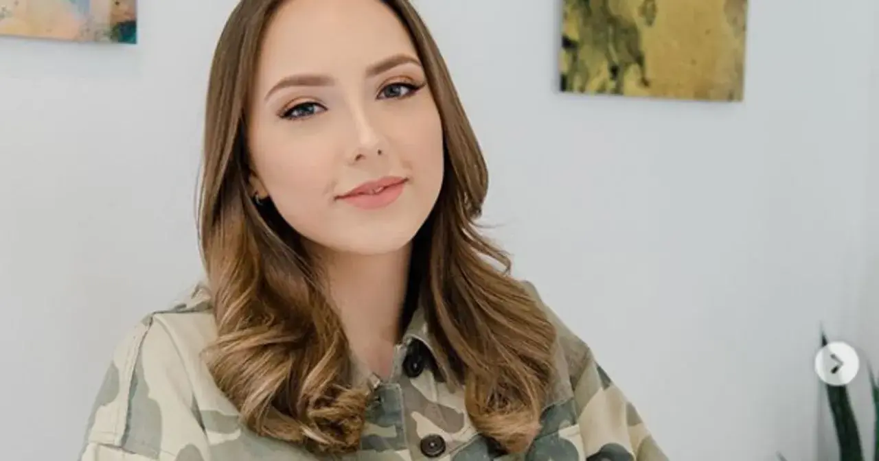 Uśmiechnięta Hailie Jade Scott Mathers w kurtce moro, z lekko pofalowanymi brązowymi włosami.