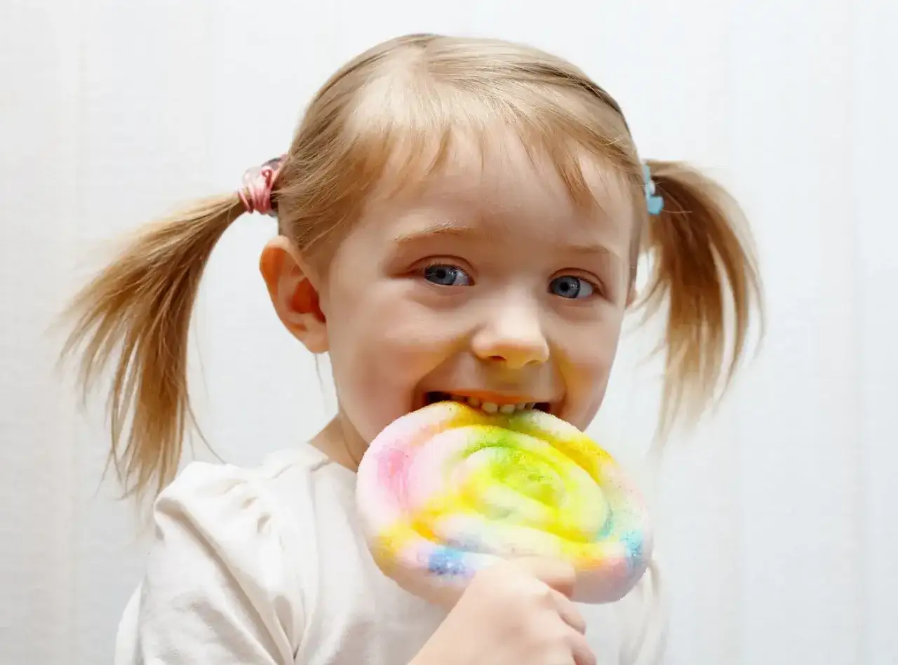 Czy dzieci celebrytów jedzą cukier i fast foody? Ta dziewczynka z pewnością cieszy się kolorowym lizakiem.