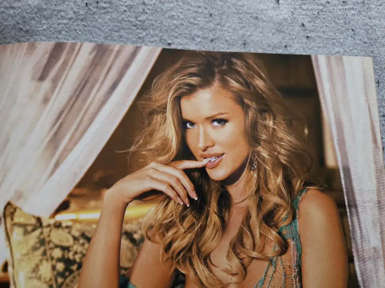 Joanna Krupa w zmysłowej sesji dla Playboya, z włosami opadającymi na ramiona i dłonią przy ustach.