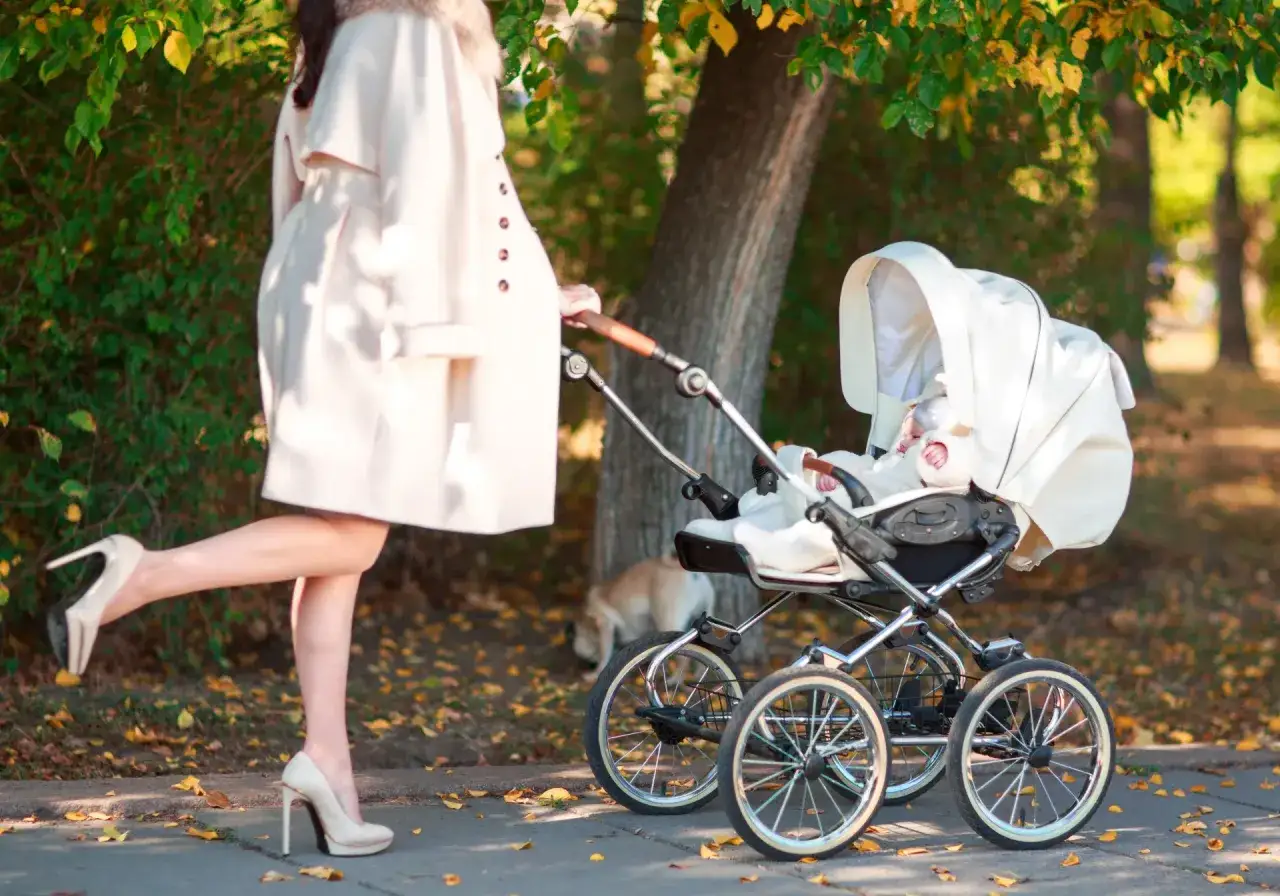 Elegancka mama pcha luksusowy wózek, który mógłby znaleźć się w rankingu najdroższych wózków dziecięcych używanych przez polskie gwiazdy.