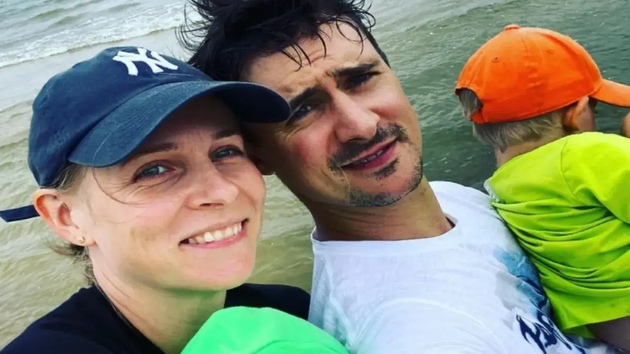Mateusz Damięcki z żoną i dzieckiem nad wodą. Uśmiechnięta rodzina cieszy się wspólnym czasem.