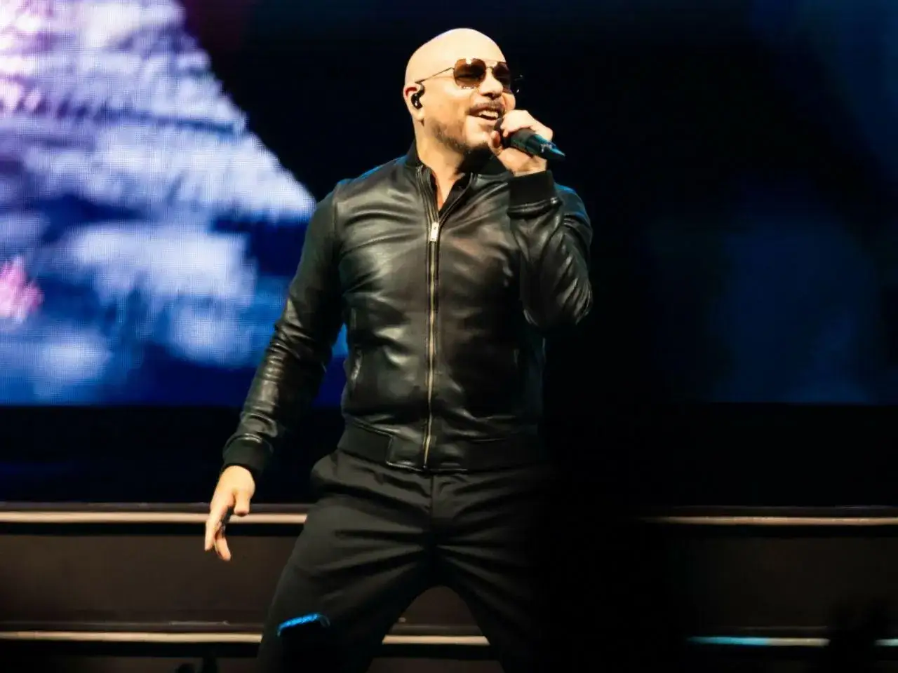 Łysy mężczyzna w skórzanej kurtce śpiewa na scenie. Czy warto kupić bilet VIP na koncert polskiej gwiazdy pop?