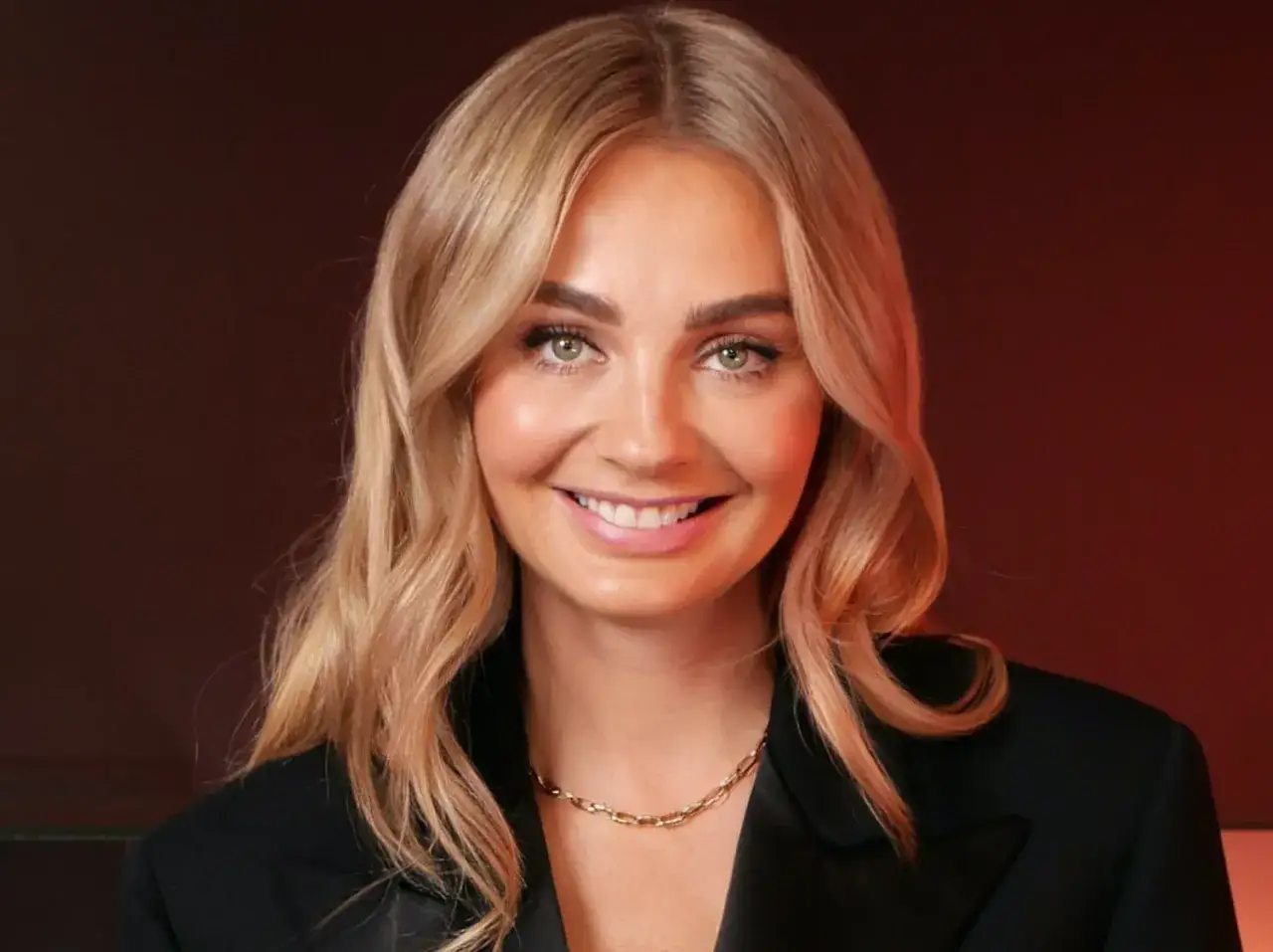 Uśmiechnięta blondynka w czarnej marynarce. Czy polskie gwiazdy zmieniają życiorysy, by lepiej pasowały do wizerunku marki?