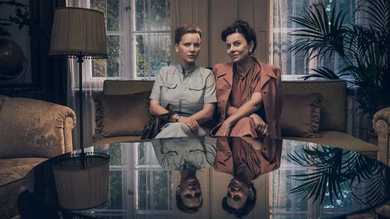 Dwie kobiety siedzą na kanapie. Jedna z nich, która polska aktorka dostała rolę w wielkiej produkcji Netflixa, ma na sobie jasnoniebieski kostium.