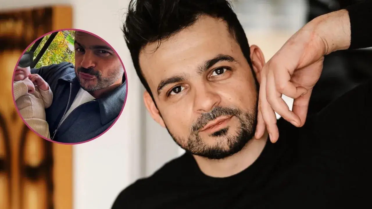 Robert El Gendy z dzieckiem na ręku, uśmiechnięty.