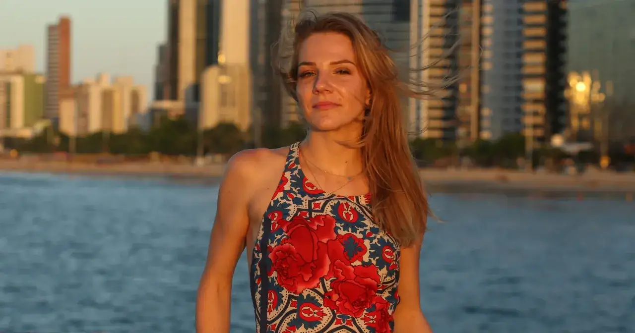 Hanna Zborowska Neves w kwiecistej sukience na tle miasta i morza.