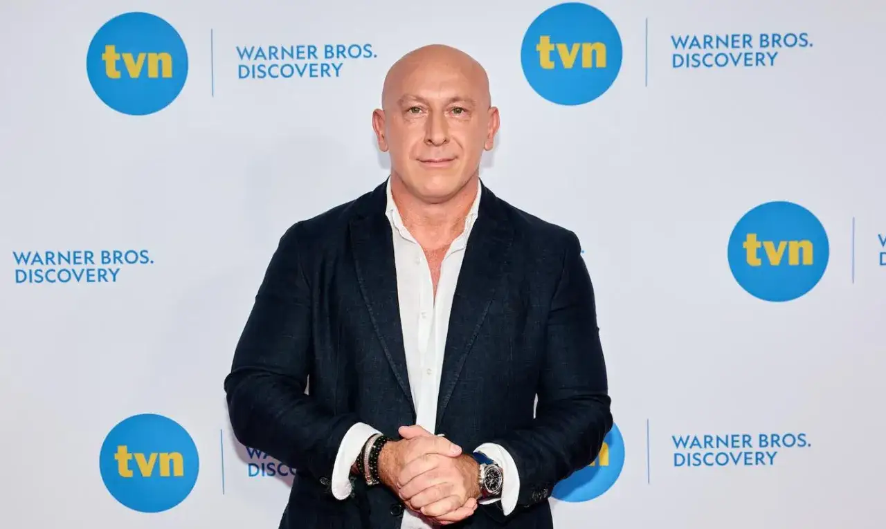 Krzysztof Miruć, łysy mężczyzna w garniturze, pozuje na tle logo TVN i Warner Bros. Discovery. Czy Krzysztof Miruć ma dzieci?