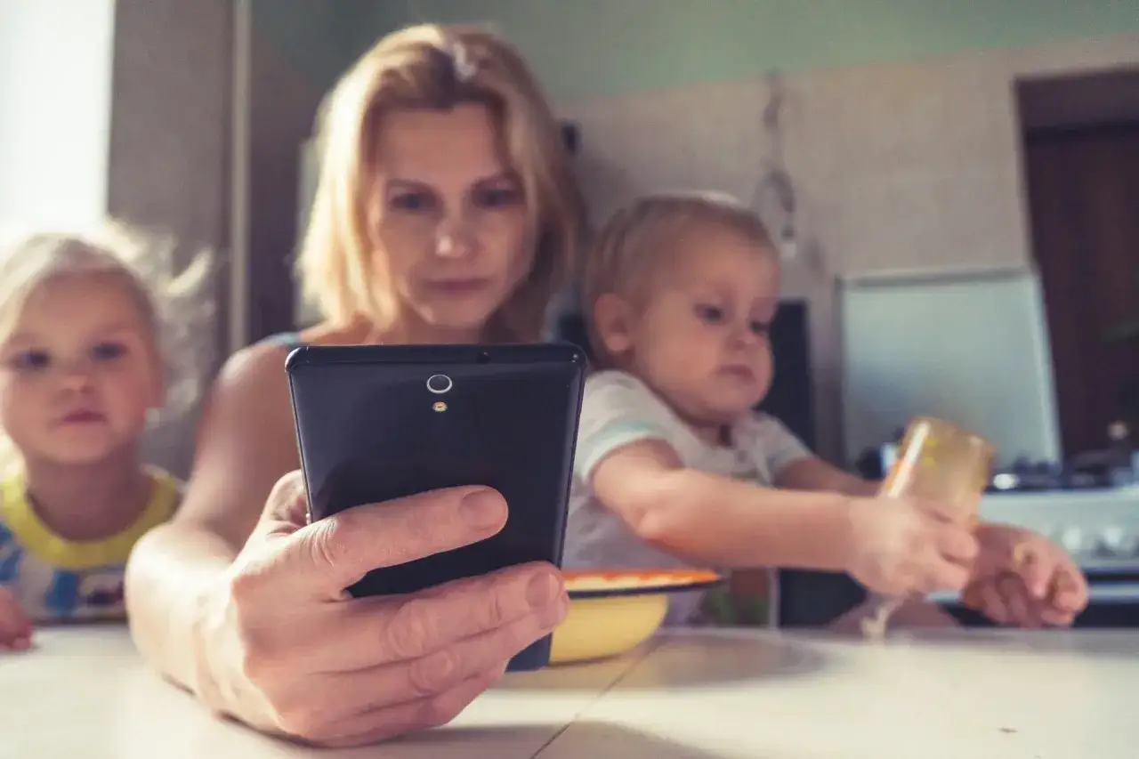 Matka z dziećmi przy stole, skupiona na telefonie. Czy to jeden z najczęstszych błędów wychowawczych celebrytów wytykanych przez internautów?