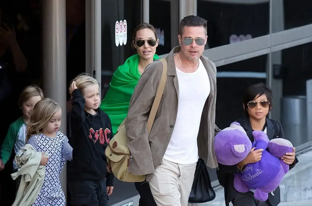 Angelina Jolie z dziećmi, w tym z synem Paxem trzymającym fioletową przytulankę, opuszczają lotnisko.