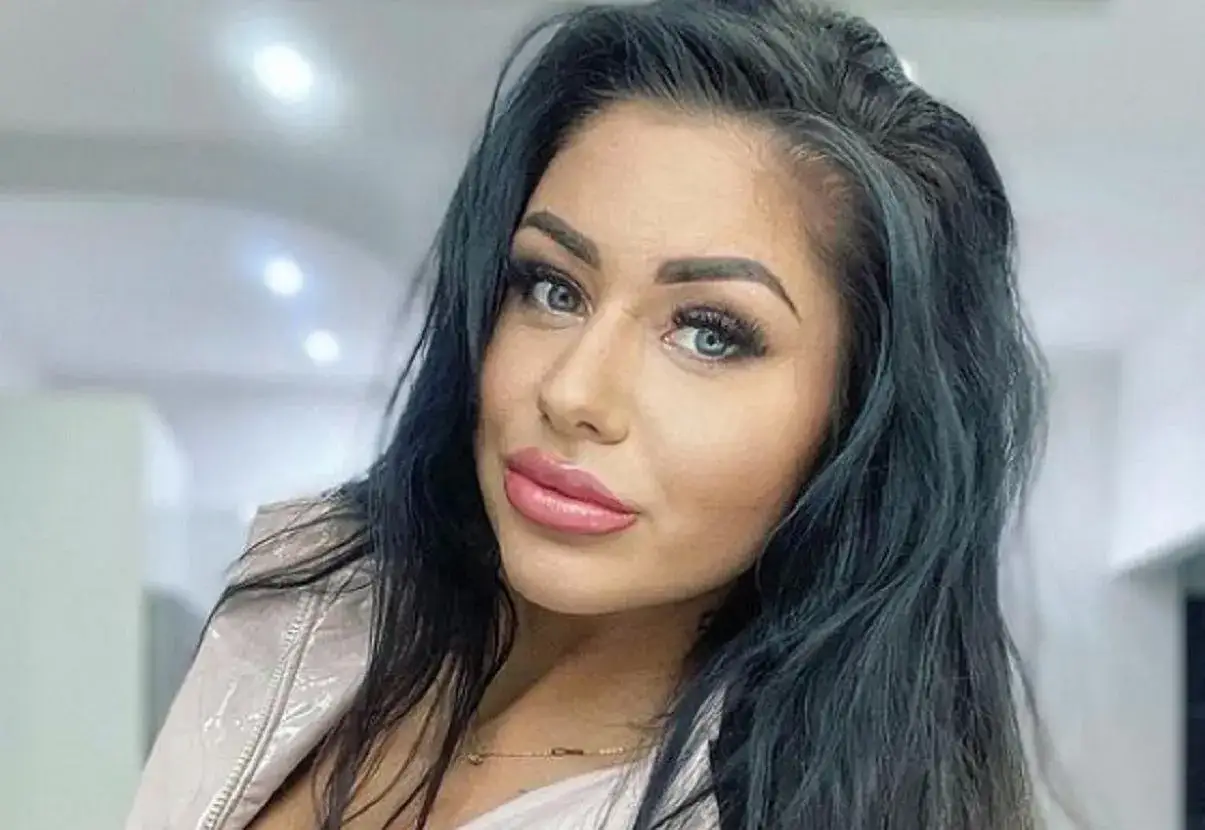 Stella z Love Island, z bujnymi, ciemnymi włosami i wyrazistymi ustami, patrzy w obiektyw.