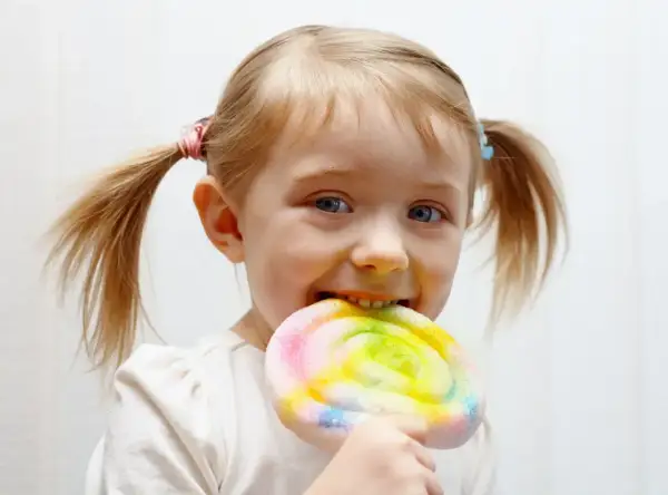Czy dzieci celebrytów jedzą cukier i fast foody? Ta dziewczynka z pewnością cieszy się kolorowym lizakiem.